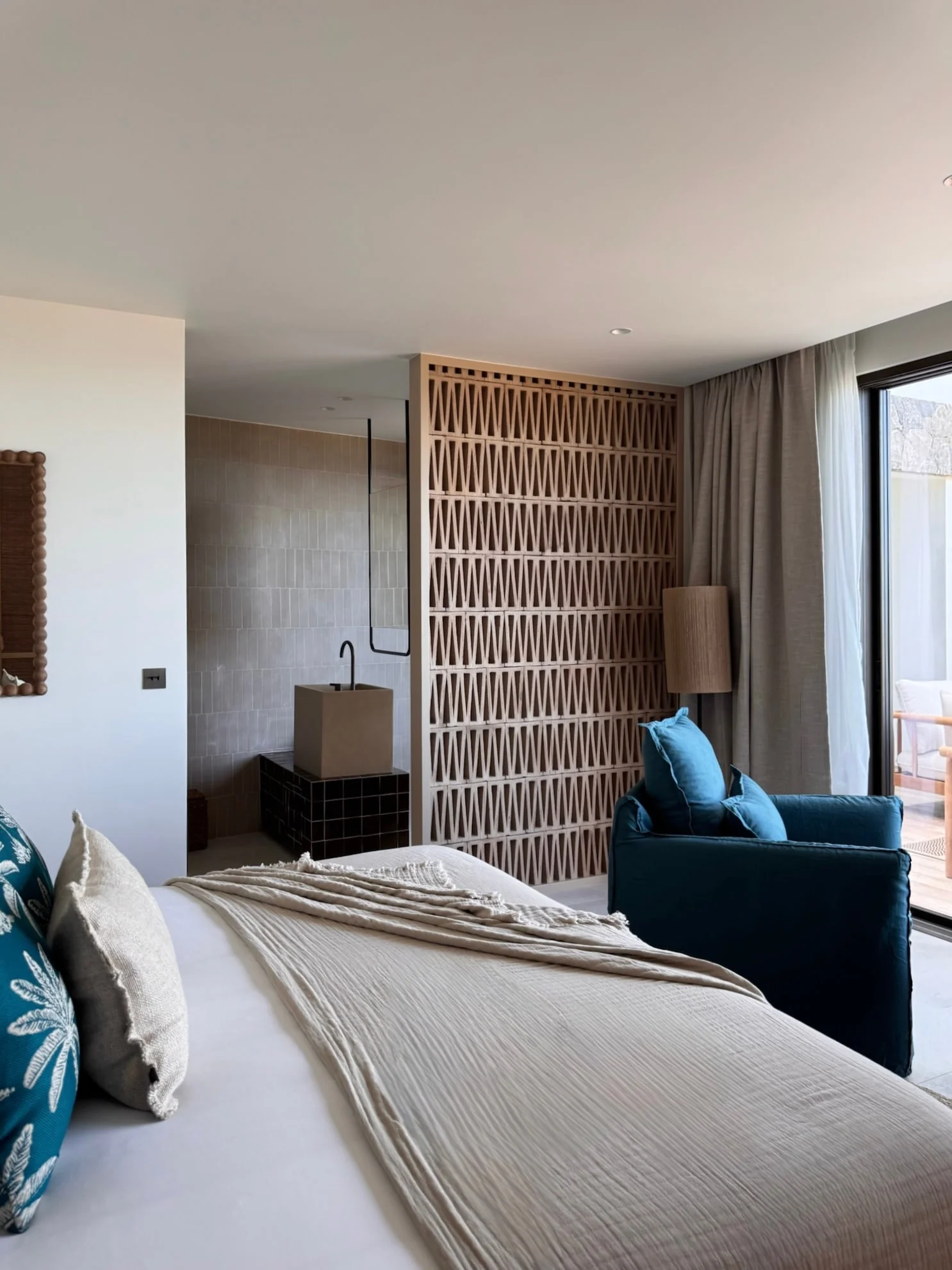 Chambre, fauteuil bleu et claustra en bois — Anse des Cayes
