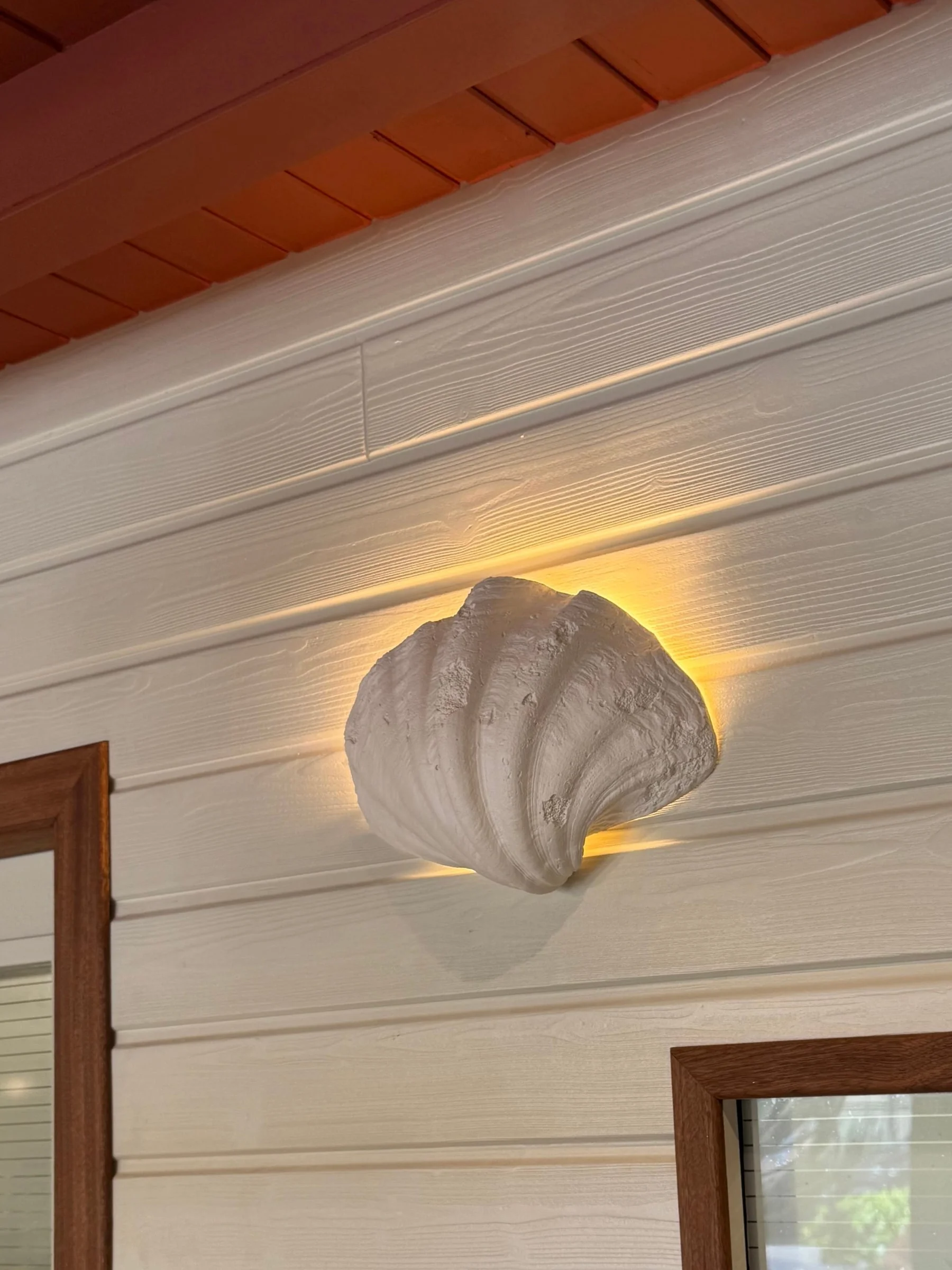 Applique coquillage sur bardage blanc — Dado Café