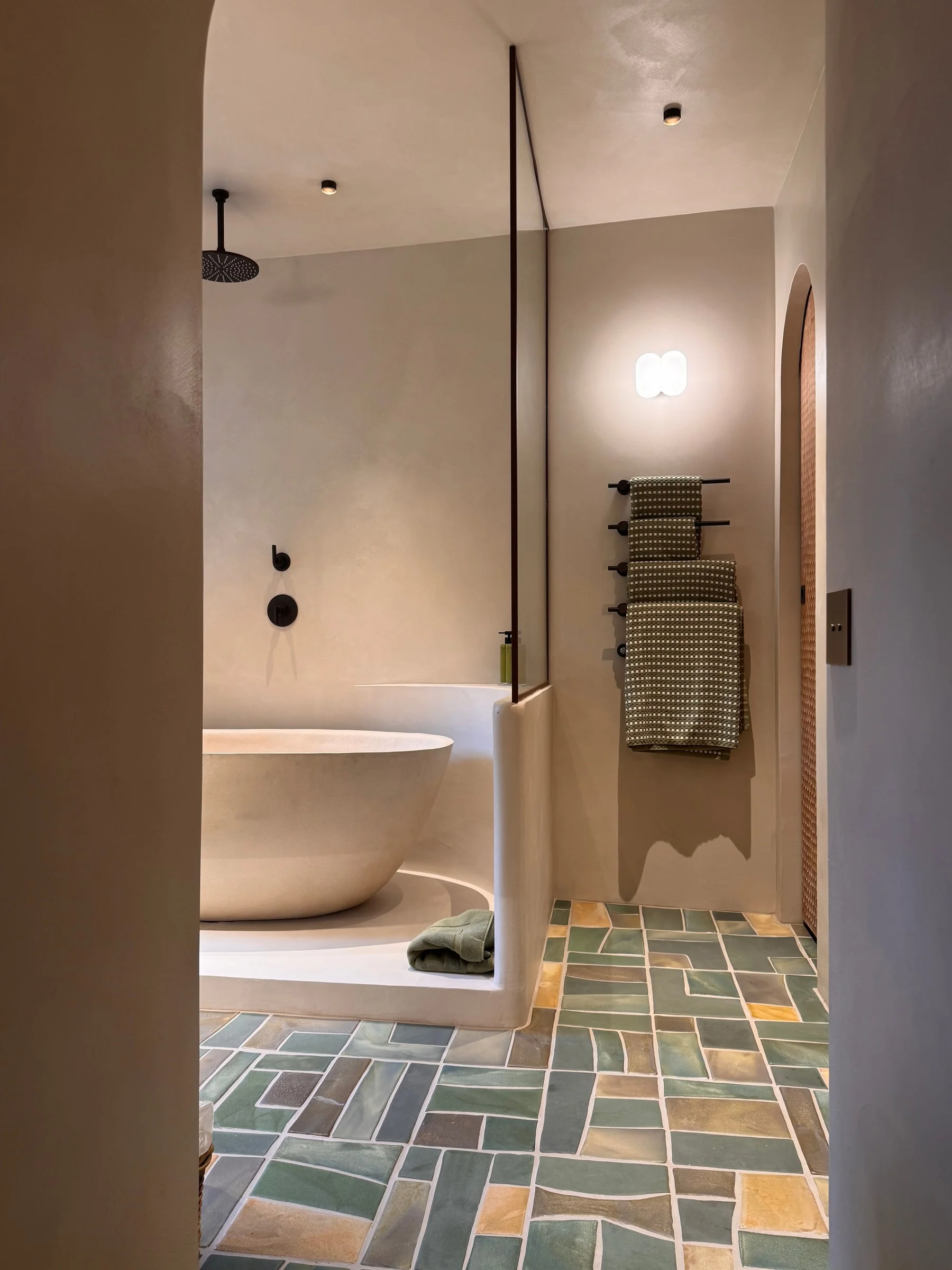 Freestanding bathtub on a floor of green and grey tiles — Fontaine