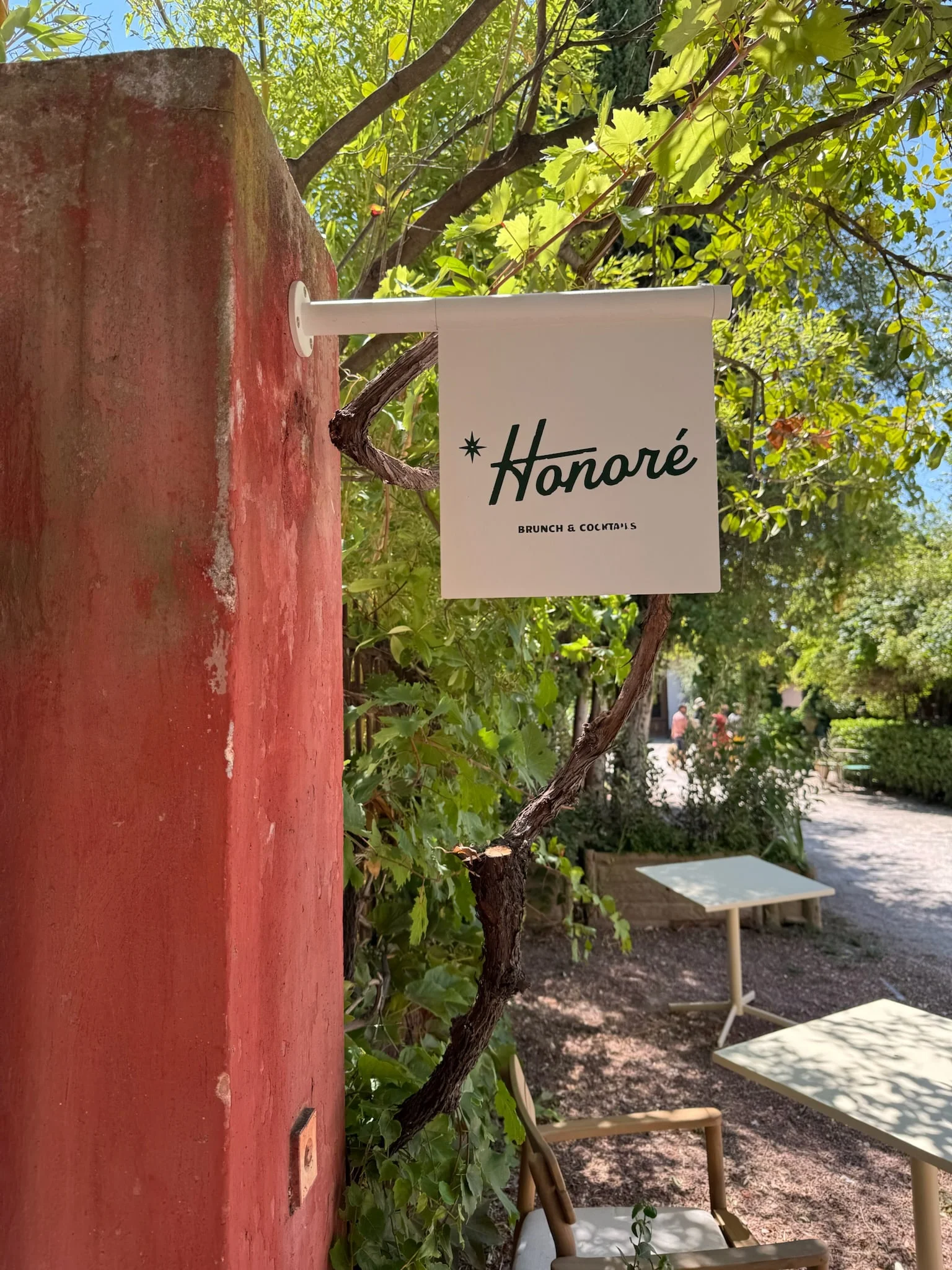 Honoré sign at the entrance, among the trees — Honoré Brunch