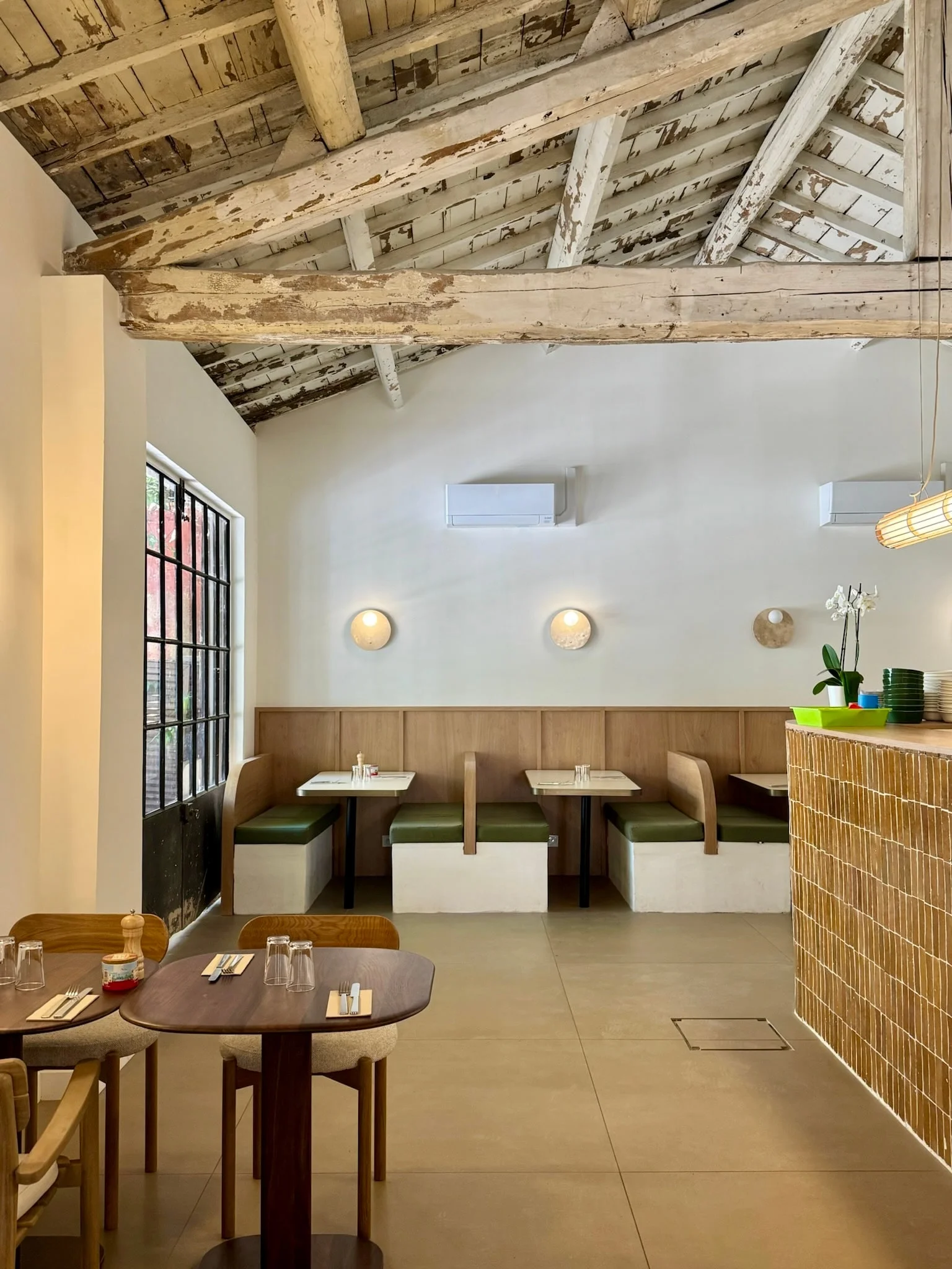 Dining room with green banquettes and wall lights — Honoré Brunch