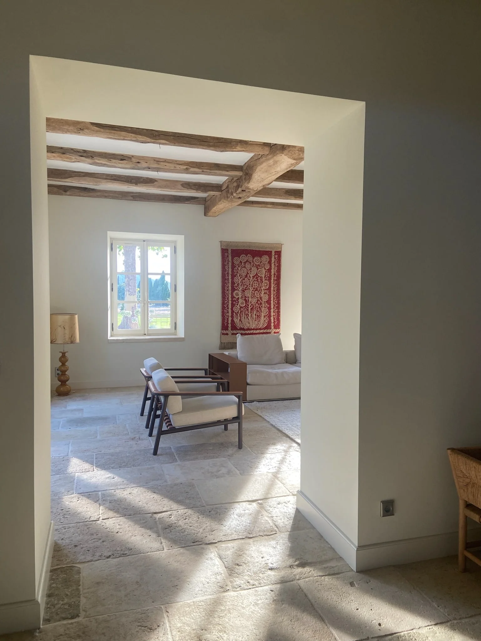 Sitting room seen through a doorway, stone floor — Montjoie