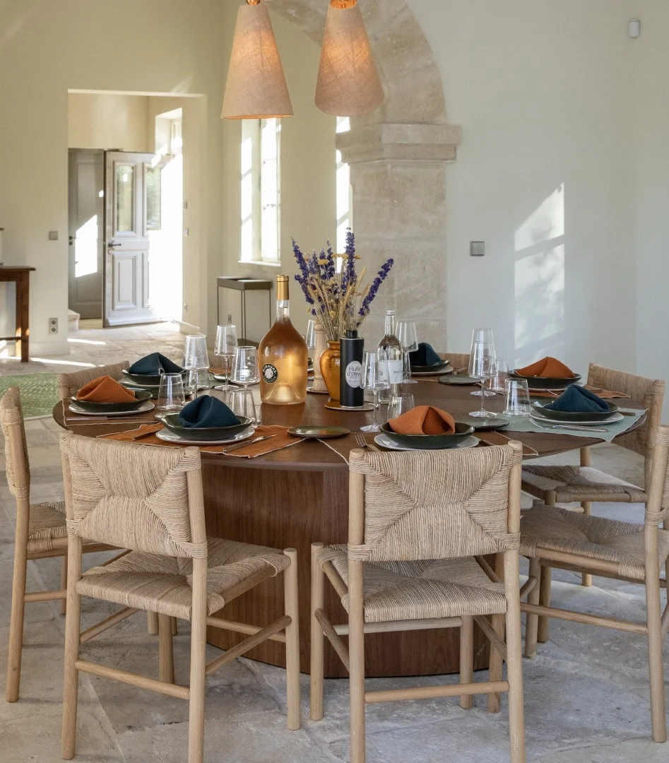Round dining table with rush chairs and woven pendant lights — Montjoie