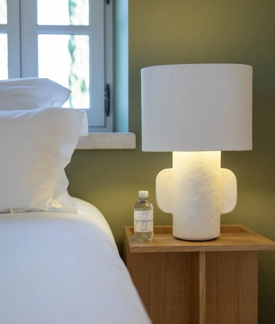 Sculptural bedside lamp against a green wall — Montjoie