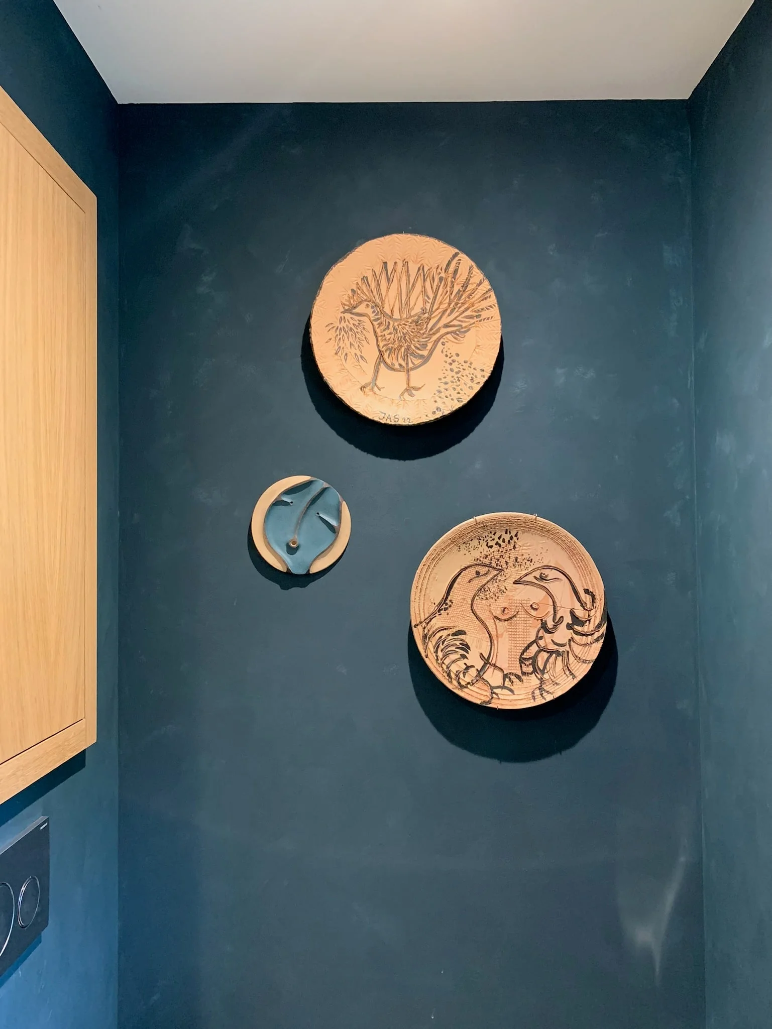 Ceramic plates on a deep blue wall — Montjoie
